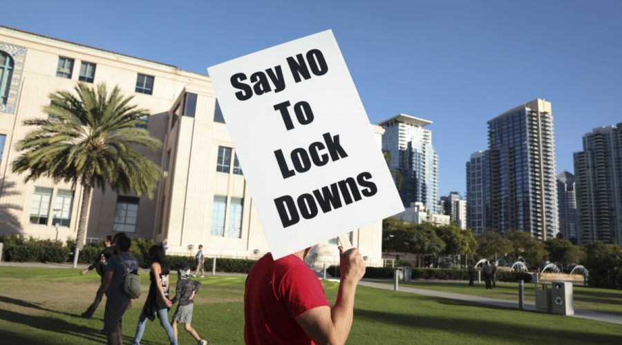 Muž drží ceduli s nápisem proti lockdonům během shromáždění u budovy okresní správy v kalifornském San Diegu, 16. listopadu 2020.